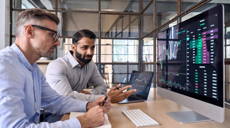 a group of men looking at a computer screen